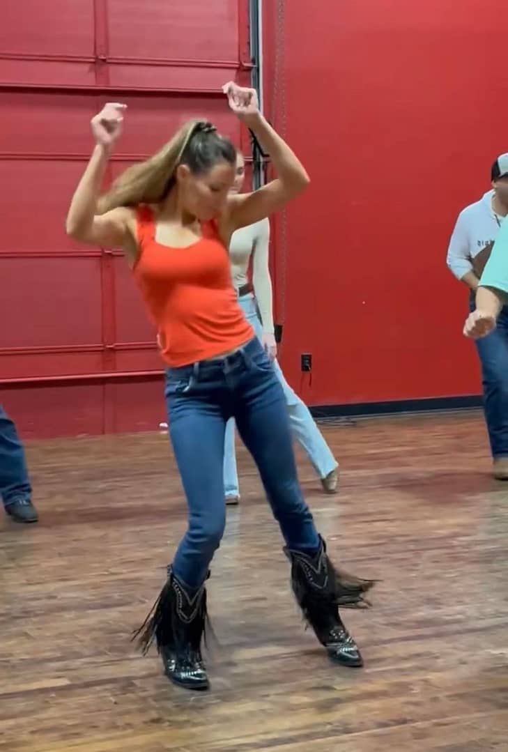 Line Dancer With Arms Up In Competition